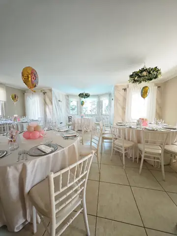 Un tavolo della sala con i palloncini e una ghirlanda di fiori