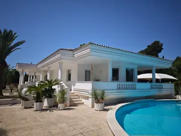 La villa bianca con la sua scalinata, affacciata sulla piscina