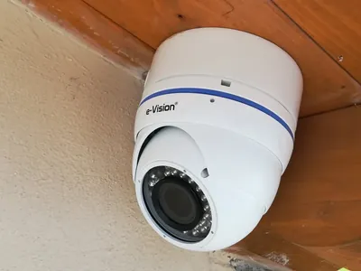 Telecamera a cupola bianca sotto una tettoia di legno