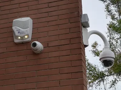 Sirena Zeta Tecnica, telecamera a cupola e telecamera motorizzata su un muro di mattoni